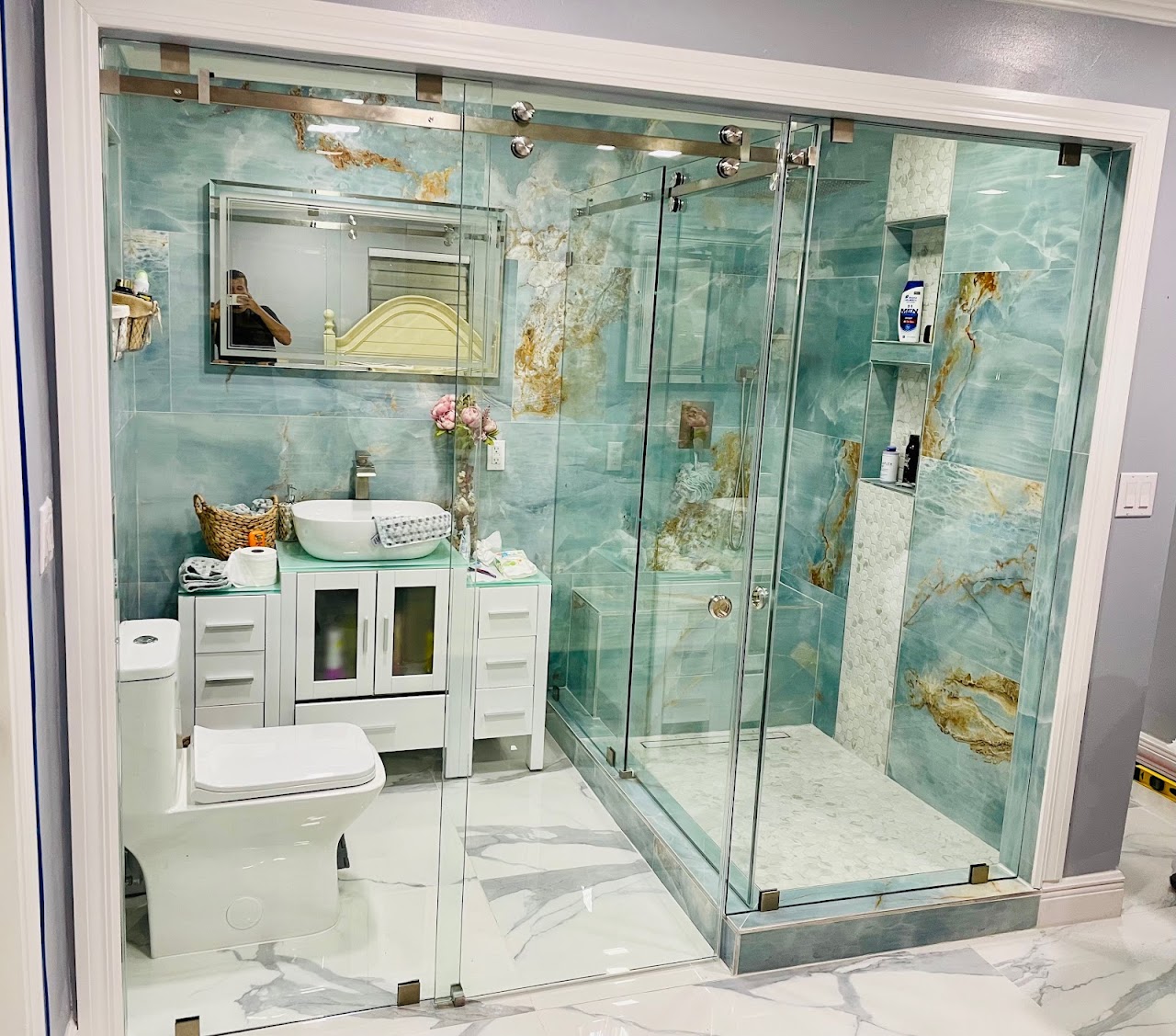 Custom glass shower enclosure with turquoise tile