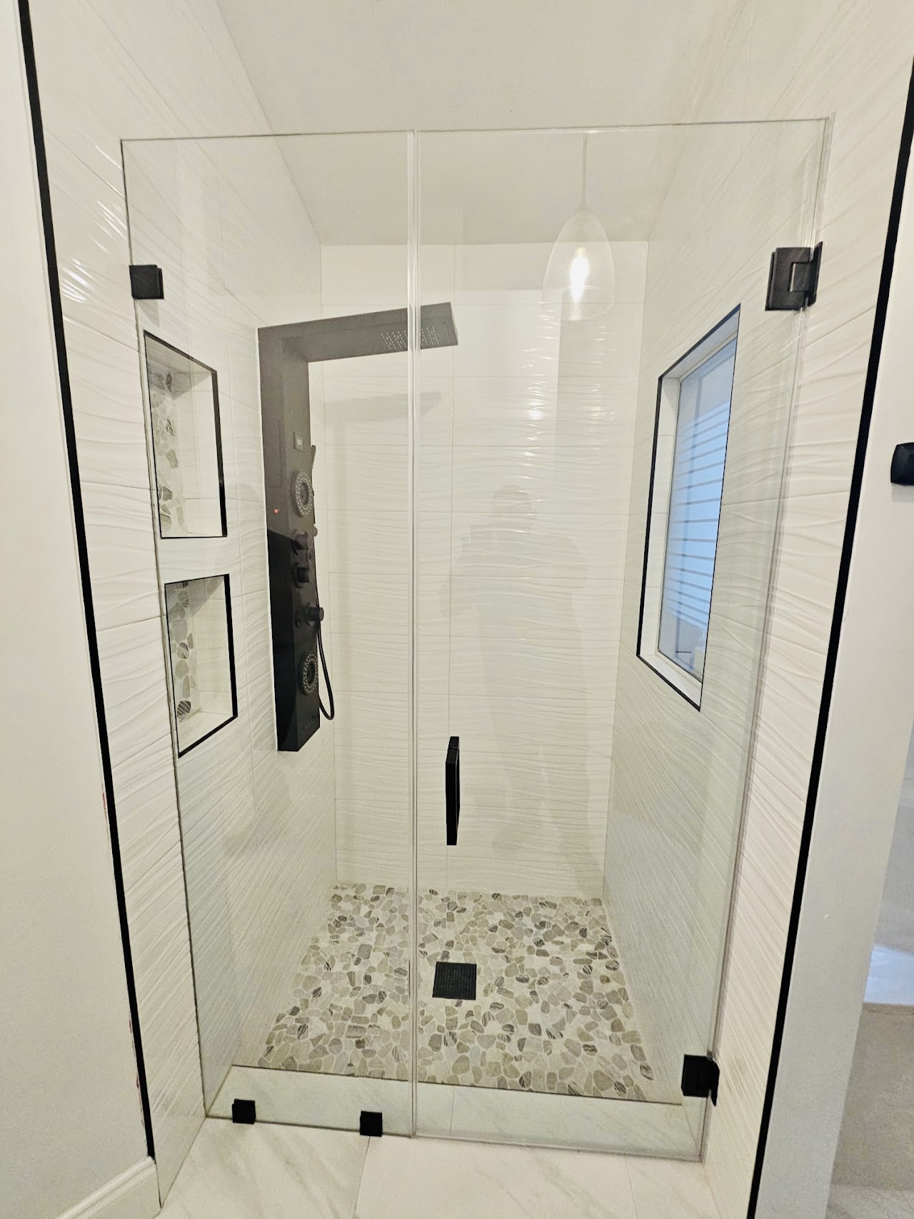 Clear glass shower door in light bathroom
