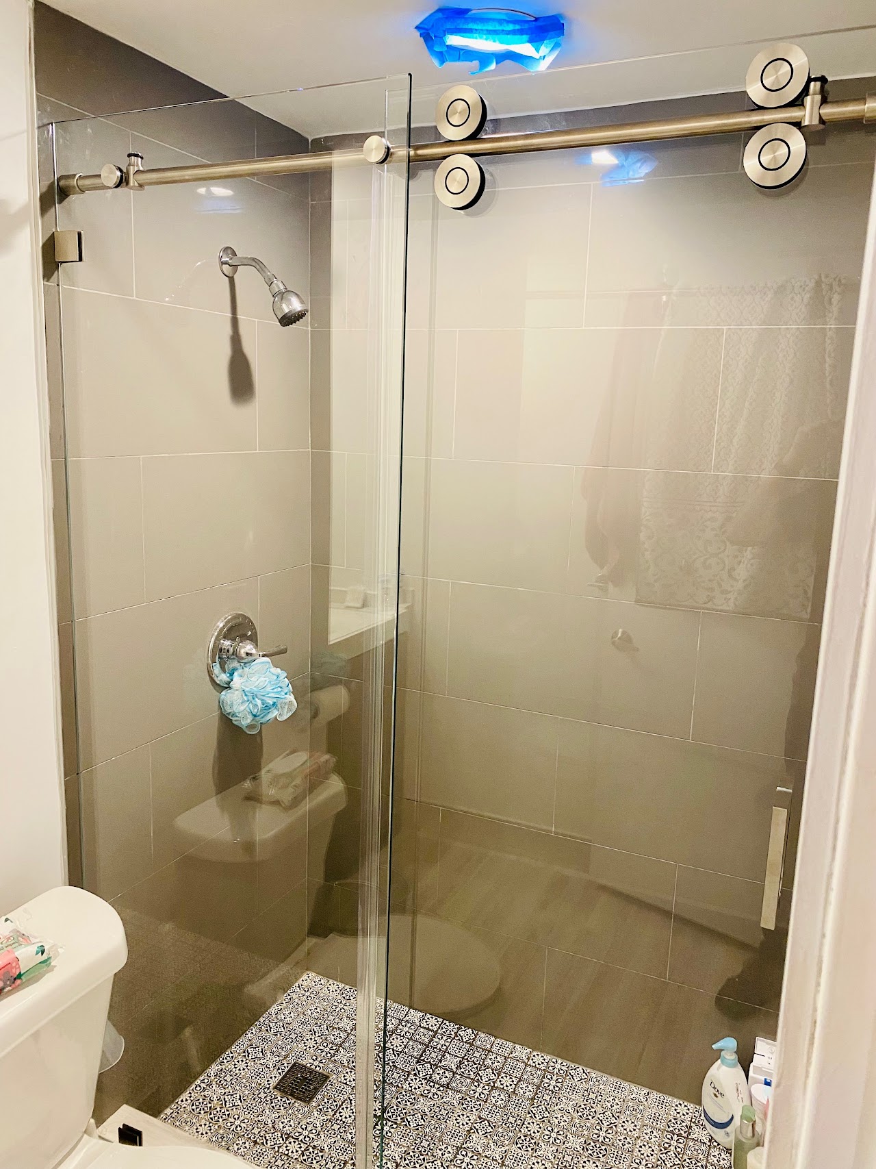 Glass shower enclosure with sliding hardware