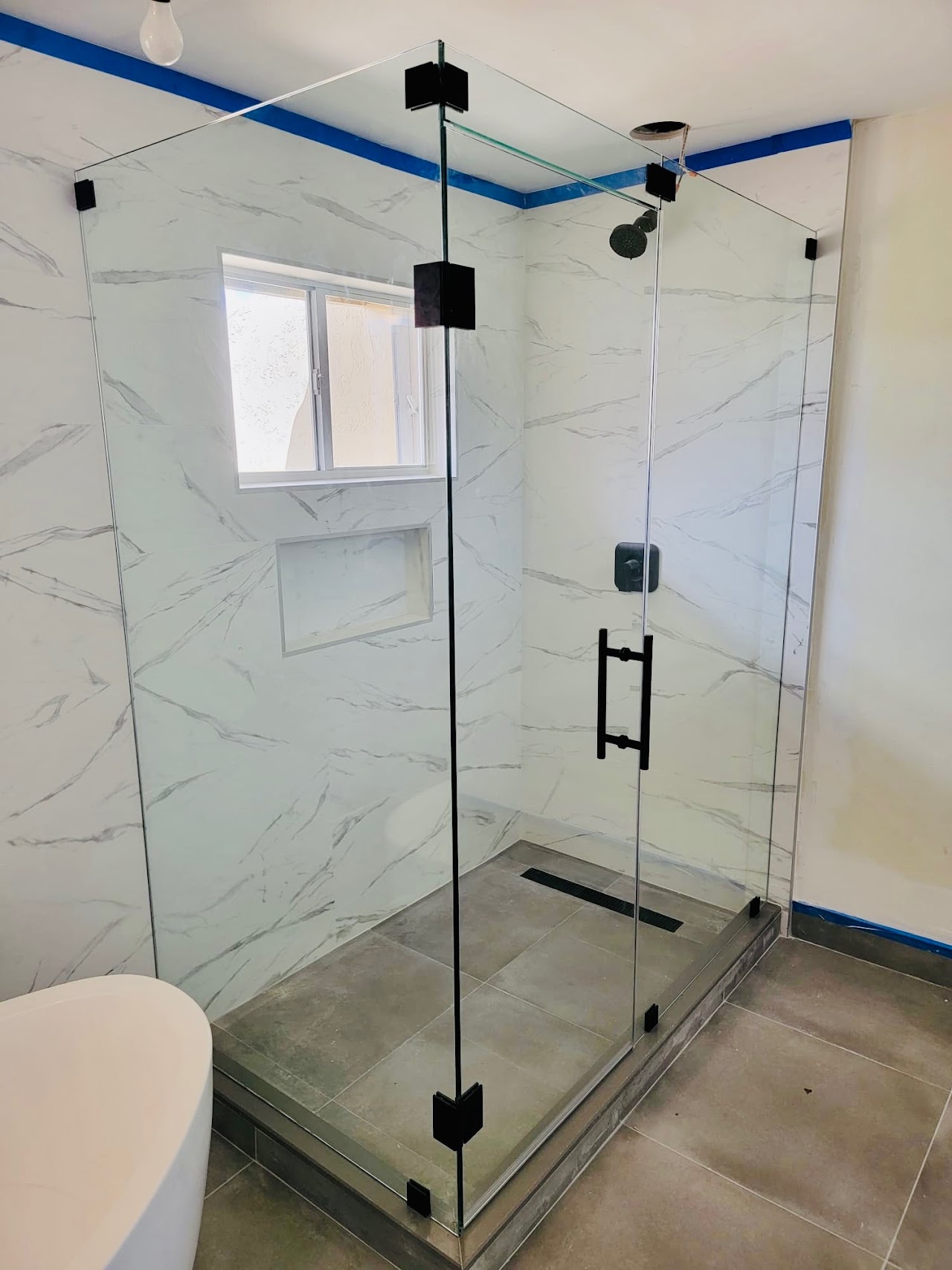 Frameless glass shower with dark fittings