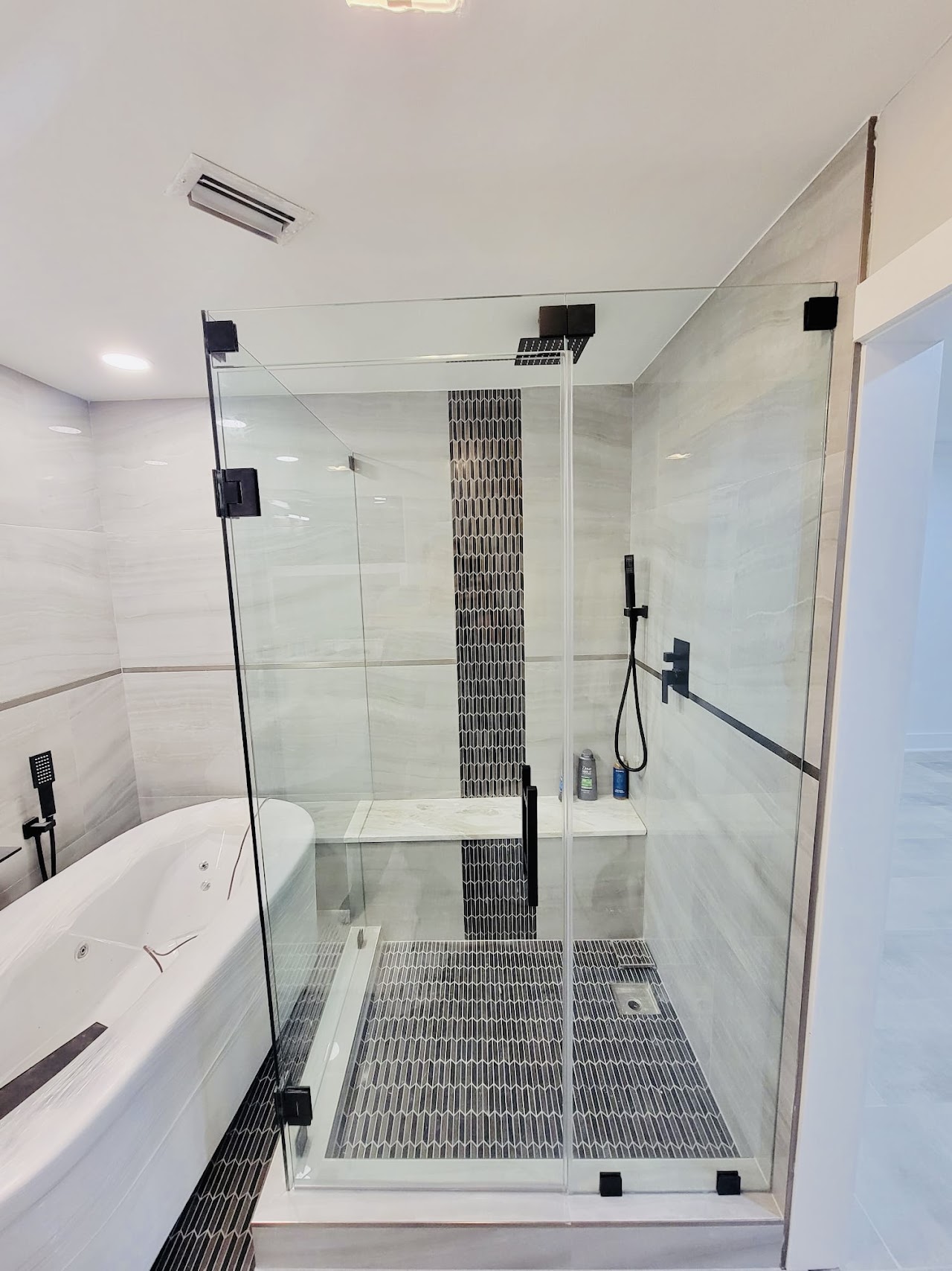Glass shower enclosure with black shower fixtures