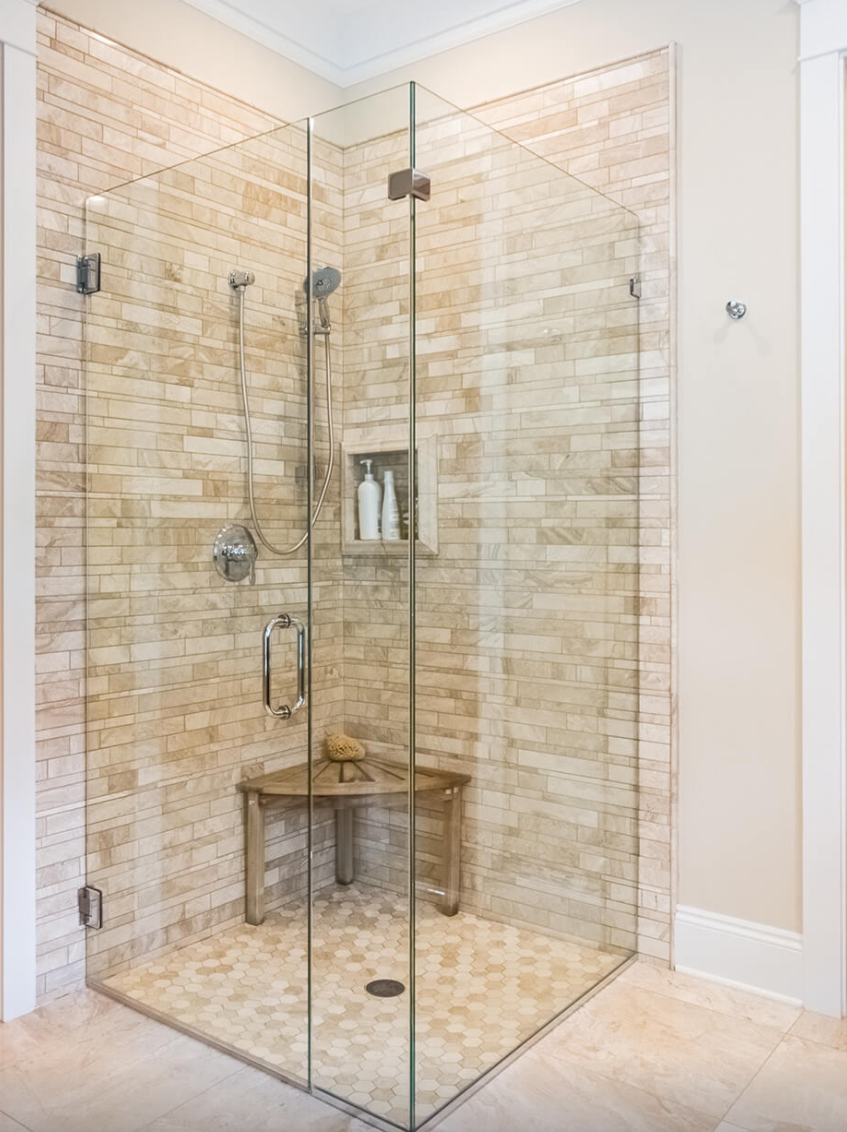Clear glass shower enclosure with beige tile